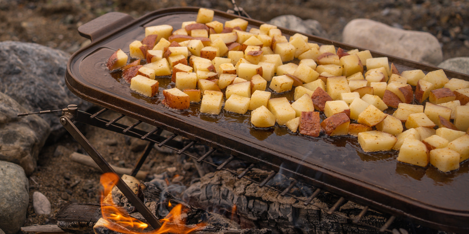 Wagner grill over fire cooking potatoes